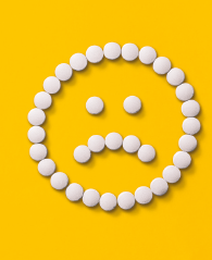 Pills arranged in a sad face emoji 